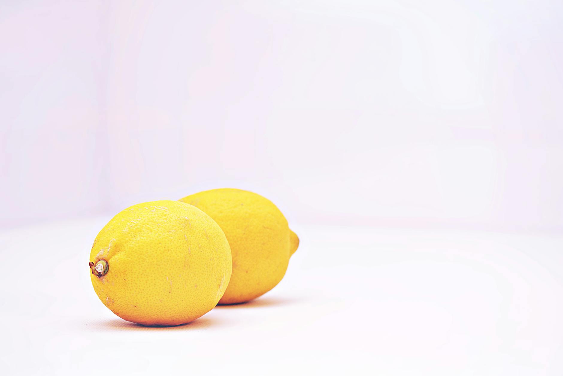 Vibrant fresh lemons on a white background, representing a fresh start to pleasure