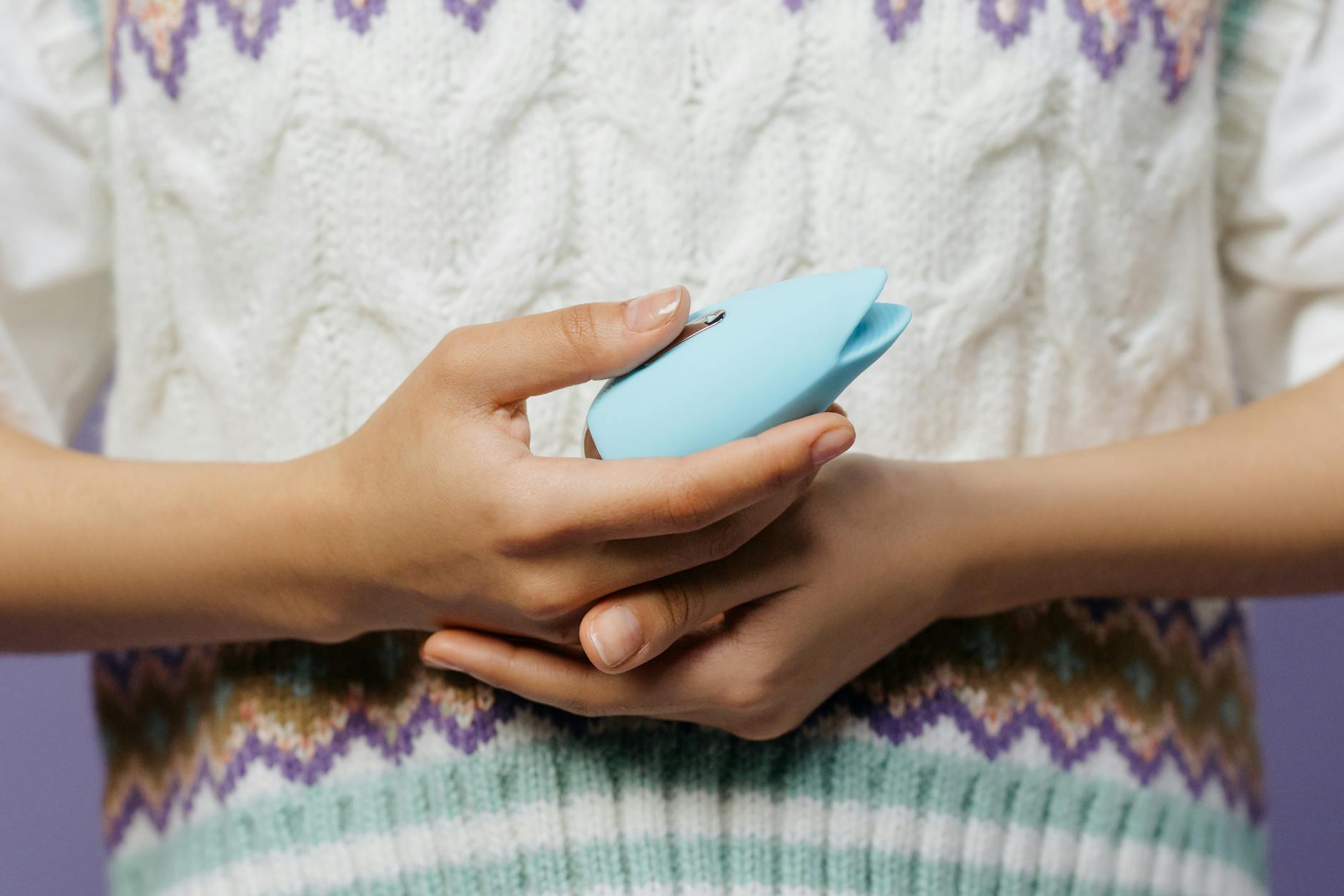 Hands holding a Lemon vibrator, ready to explore pleasure on your own timeline.