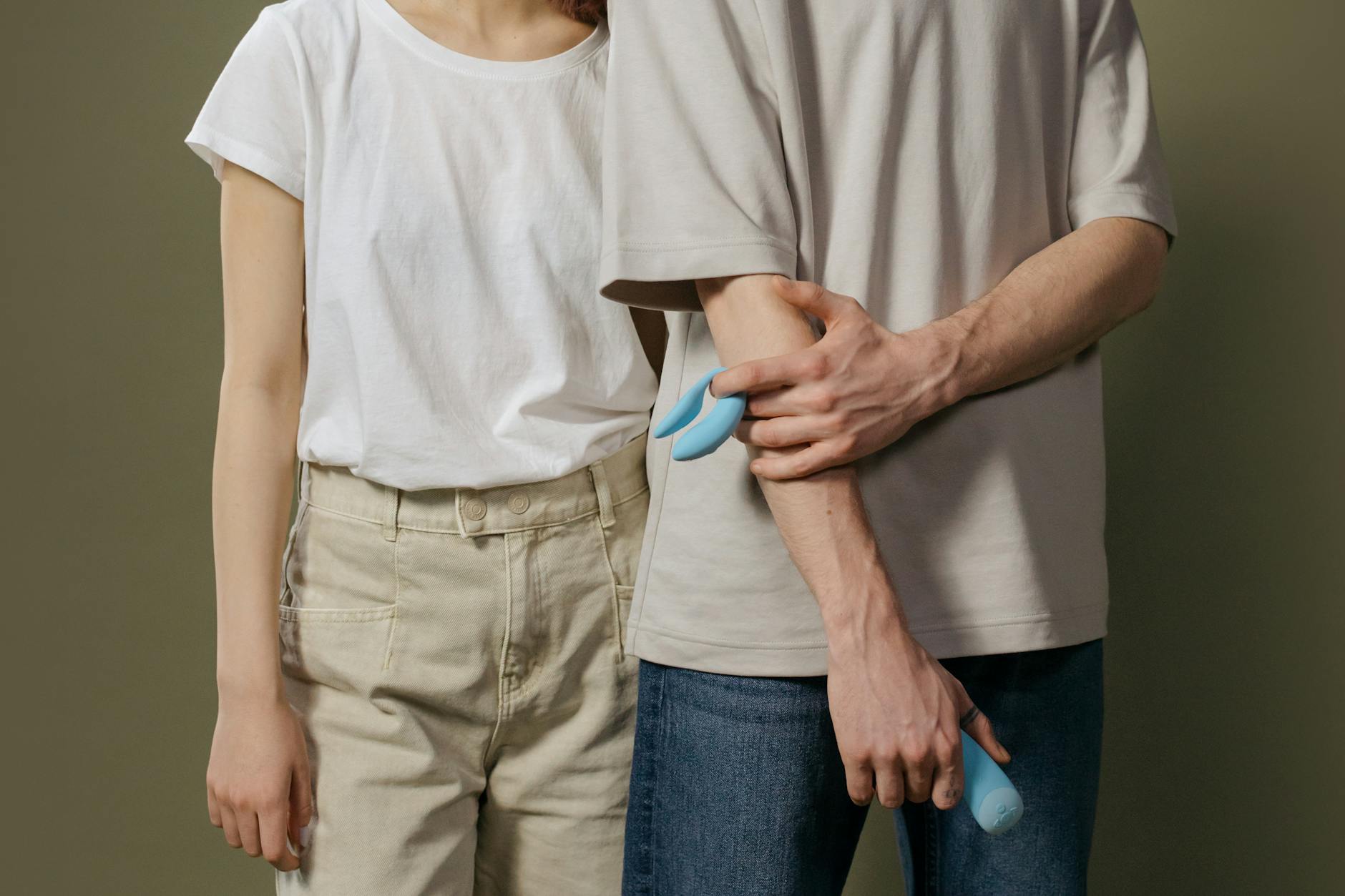 A young couple standing together indoors, discussing intimacy and pleasure with modern tools